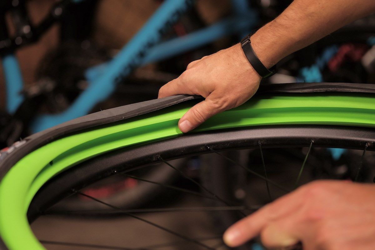 Pneu de vélo tout terrain perforé ou crevé, avec mousse visible s'échappant  par les trous perforés. Système sans chambre à air sur un mur de pneus de  vélo d'étanchéité Photo Stock 